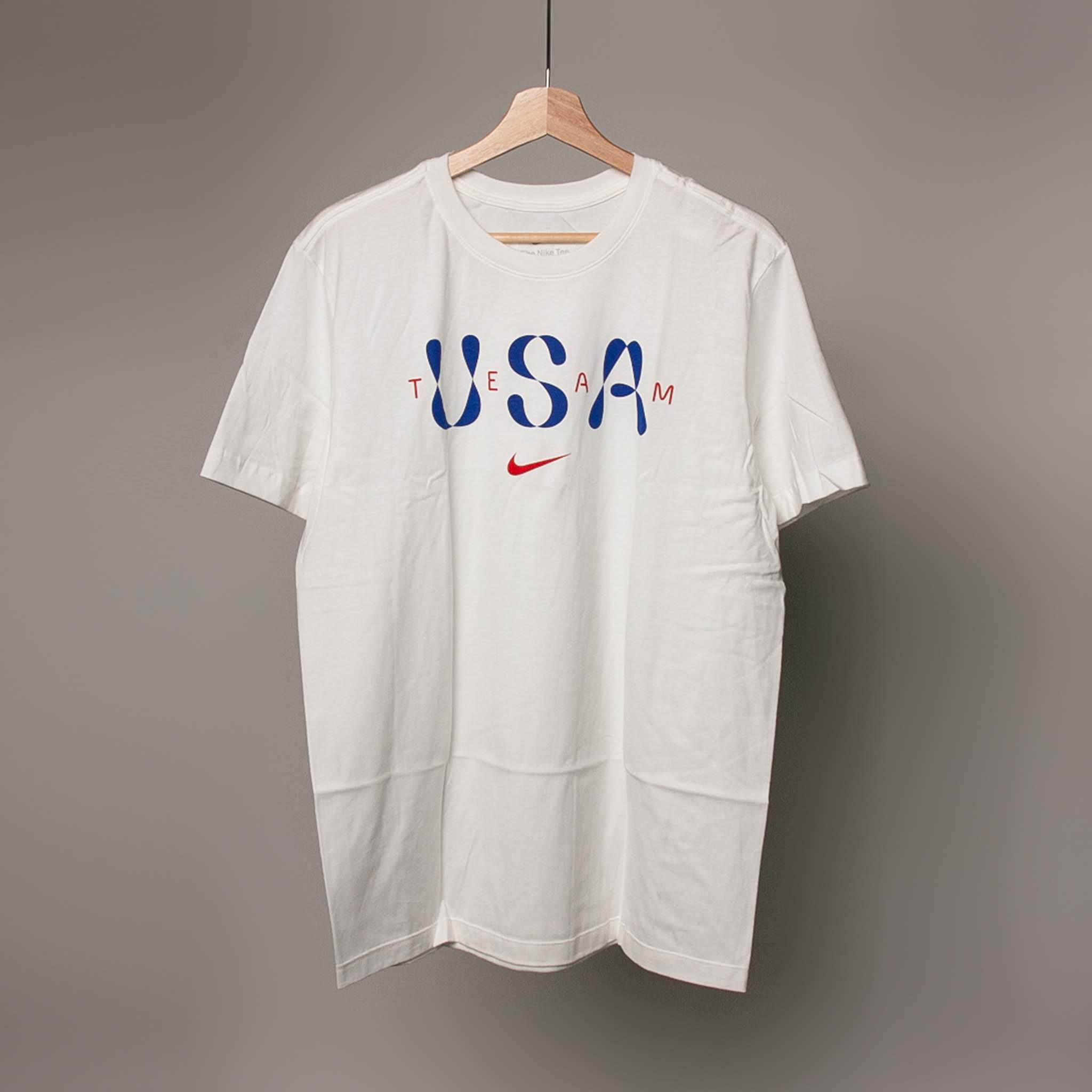 The shirt features 'USA TEAM' printed across the chest in blue block letters with red accents, and a small red Nike swoosh logo underneath.